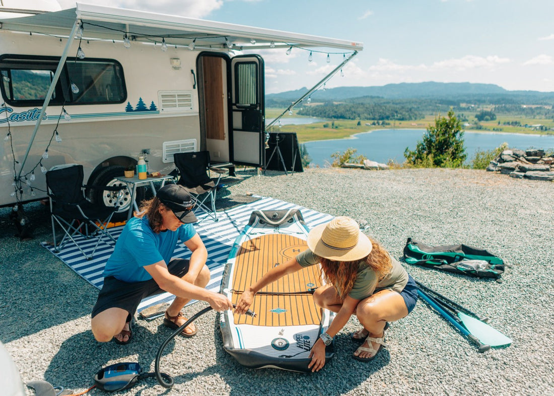 Hibear Adventure Flask at a lakeside camper stop with two travelers preparing a paddleboard